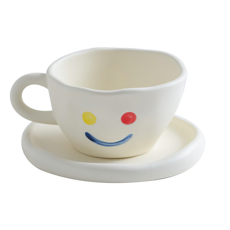 Tazza con piattino in ceramica color bianco con faccina sorridente