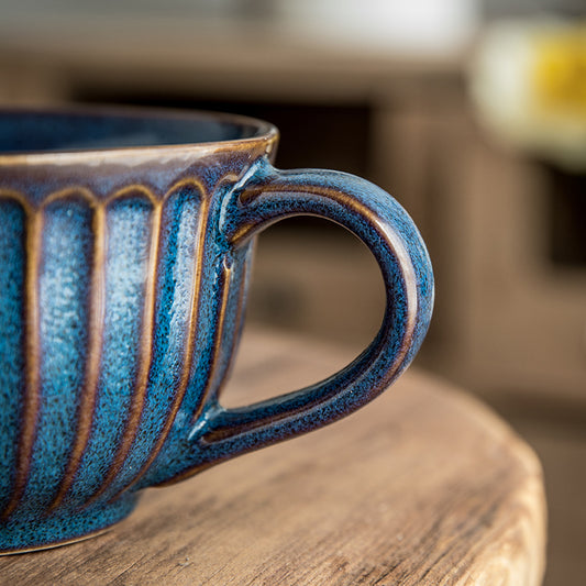 Tazza in ceramica con disegni in rilievo e cucchiaino dorato