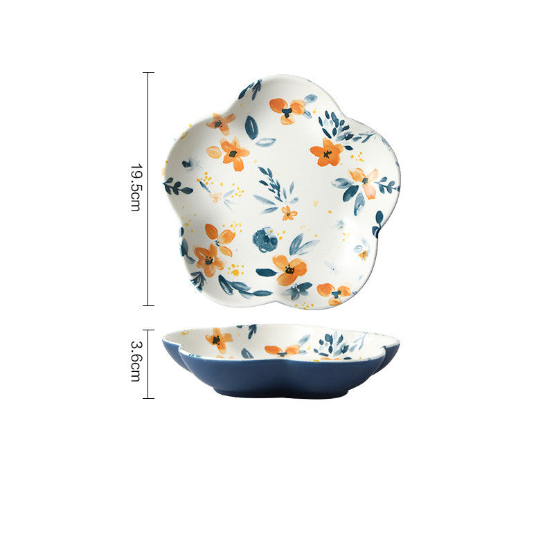 Piatti e ciotole in ceramica con fiori arancioni e foglie blu