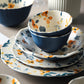 Piatti e ciotole in ceramica con fiori arancioni e foglie blu