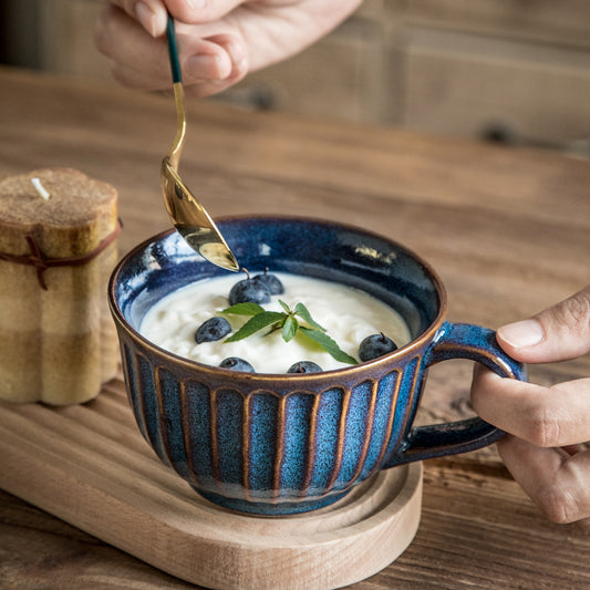 Tazza in ceramica con disegni in rilievo e cucchiaino dorato