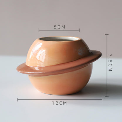 Vaso di ceramica a forma di pianeta con anello circolare intorno
