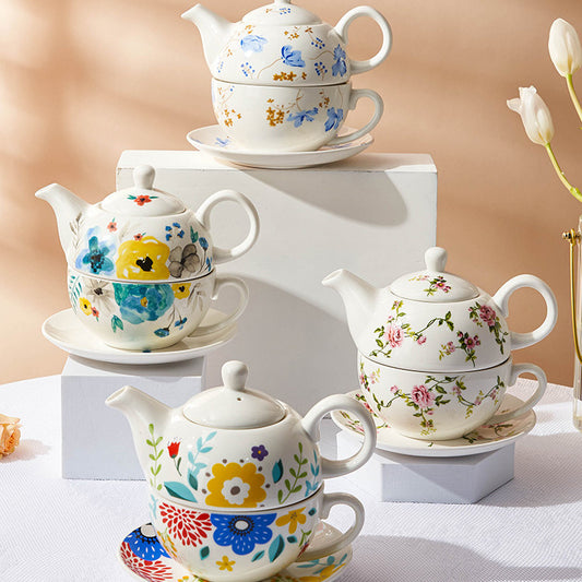 Set teiera, tazza e piattino in porcellana con delicati motivi floreali