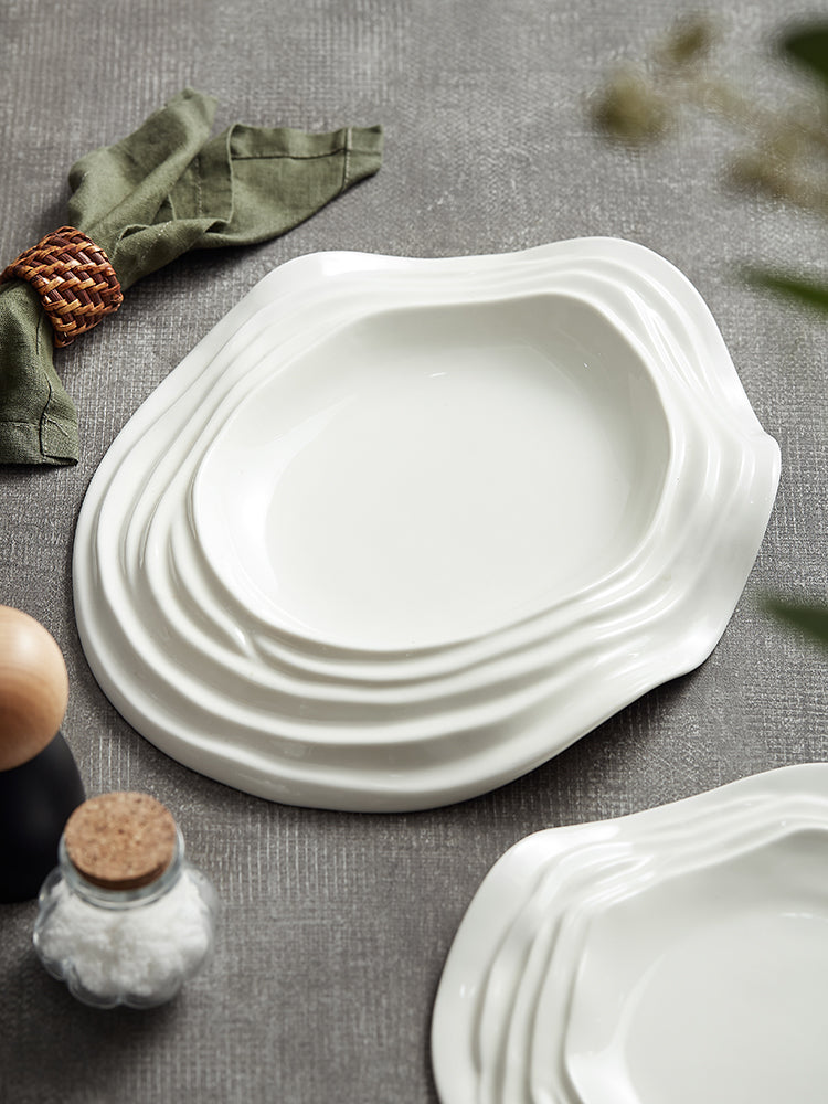 Piatto bianco in ceramica con bordi ad onde astratte ed irregolari