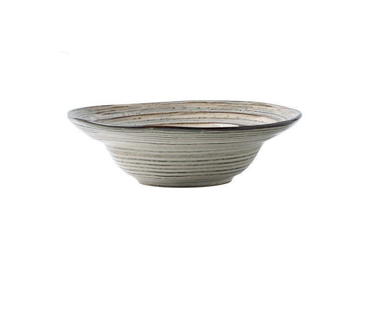 Piatto con forma irregolare e design in rilievo realizzato in ceramica