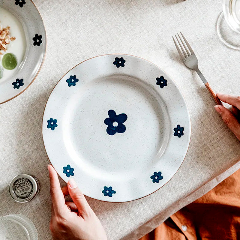 Piatti, ciotole e pentolini in ceramica con un fiore blu