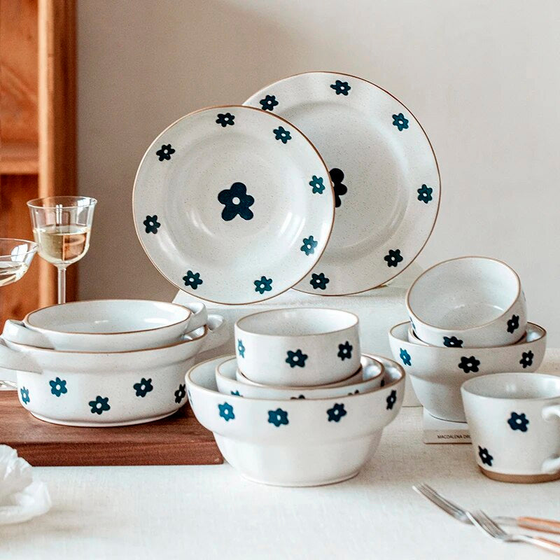 Piatti, ciotole e pentolini in ceramica con un fiore blu