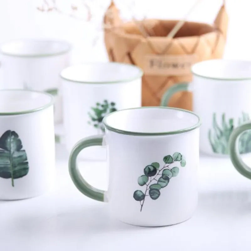 Tazza in ceramica con manico verde, foglie e piante verdi