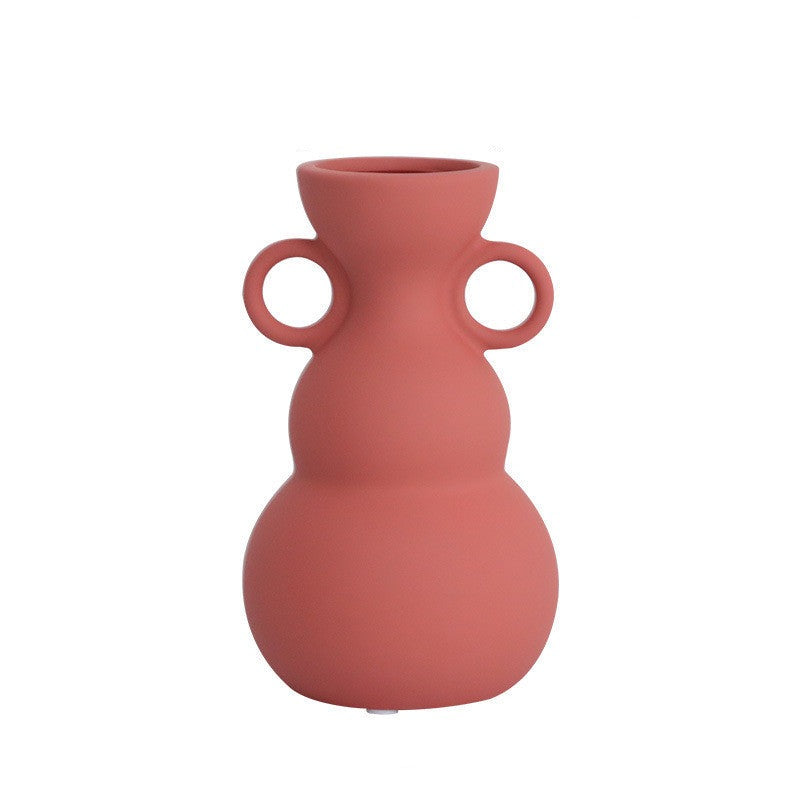 Vaso in stile Morandi, realizzato in ceramica, con manico rotondo e colori vivaci.