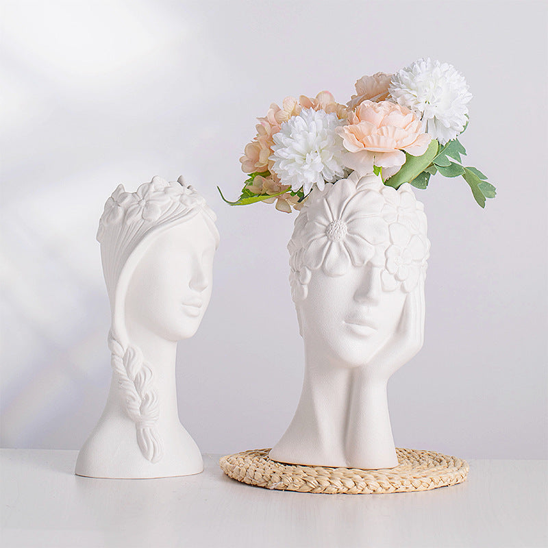Vaso bianco in ceramica a forma di testa di donna con coroncine di fiori